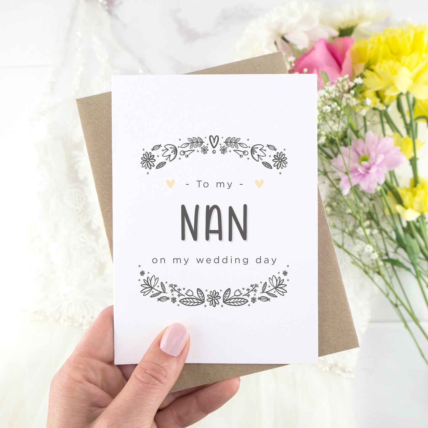 To my nan on my wedding day. A white card with grey hand drawn lettering, and a grey floral border. The image features a wedding dress and bouquet of flowers.