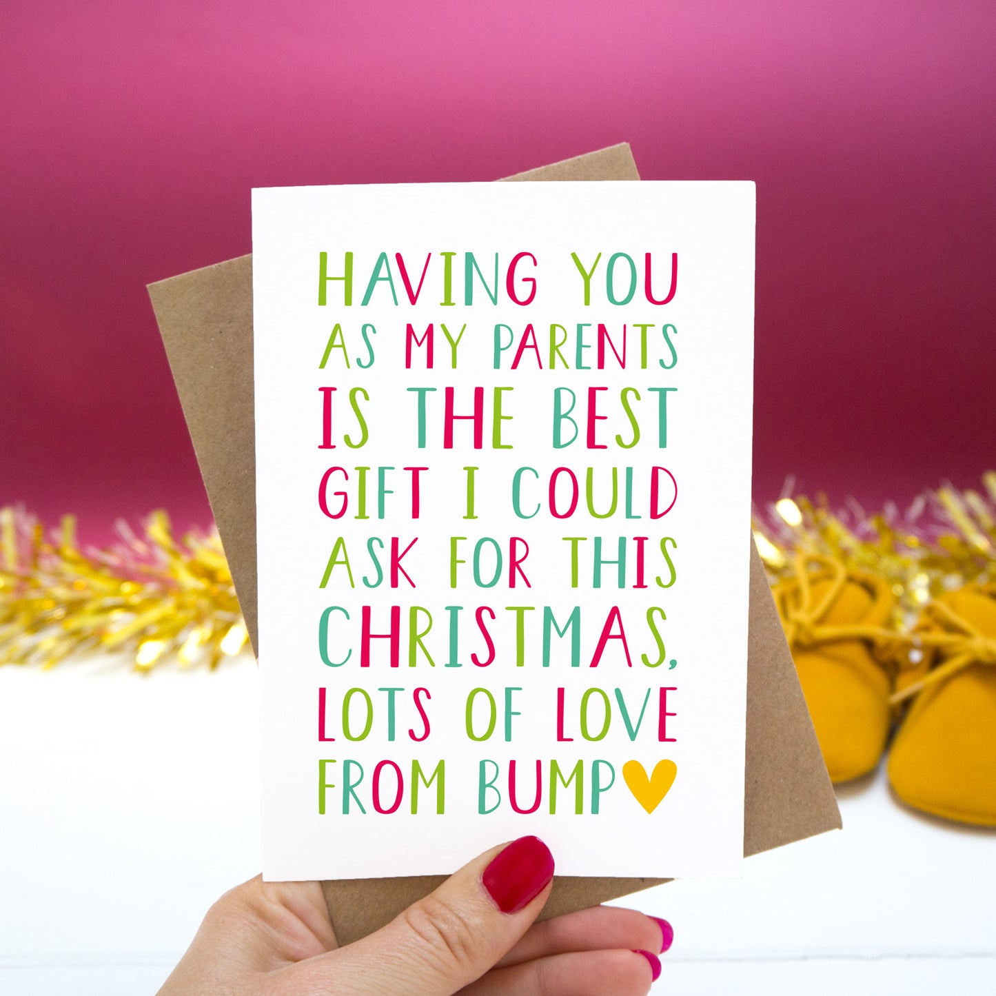 Having you as my Parents is the best gift I could ask for this Christmas, lots of love from bump." - Christmas bump card with red and green text set on a red background with gold tinsel and mustard shoes.