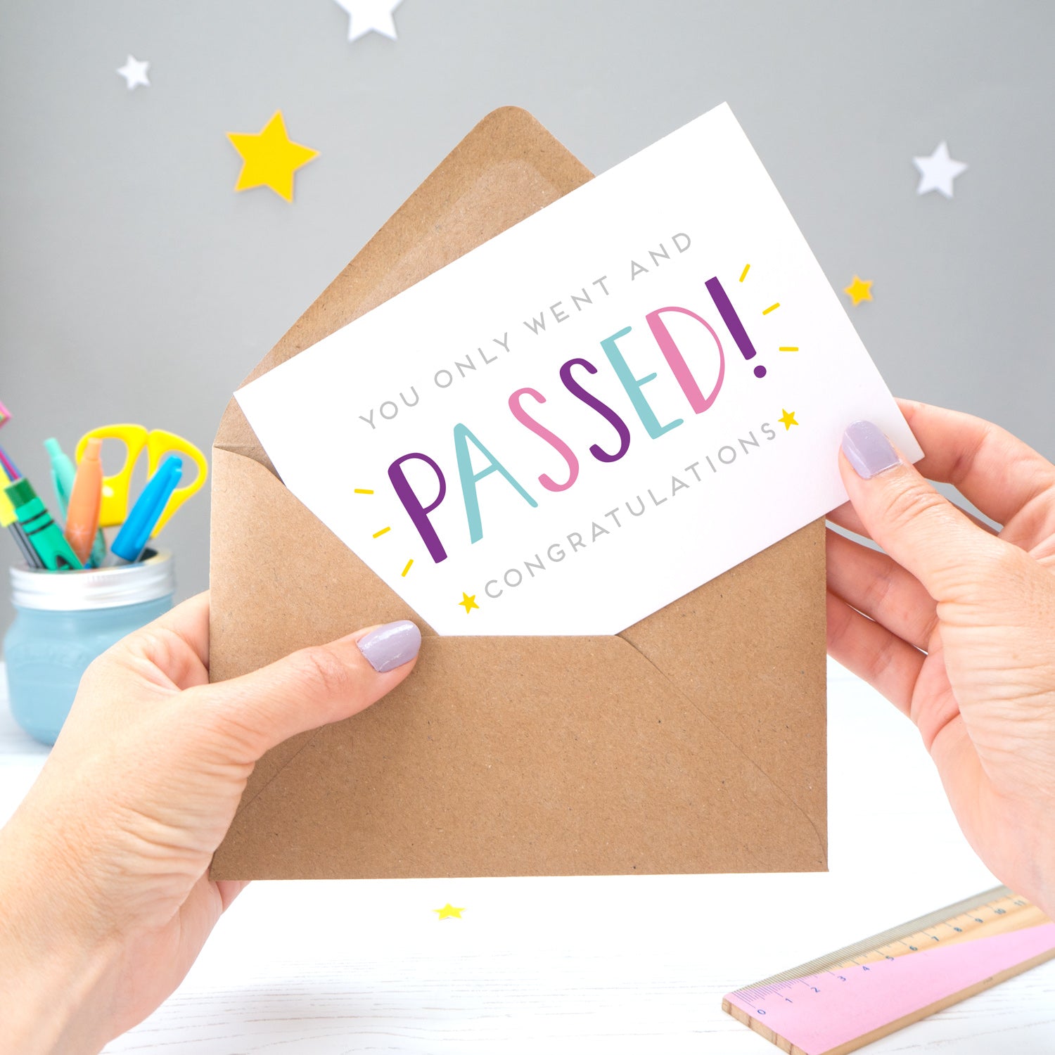 'You only went and passed! Congratulations!' A congratulations card for someone who has completed their exams recently. It features grey text with the word 'passed' in a hand lettered font with varying tones of blue, pink and purple, and yellow stars.