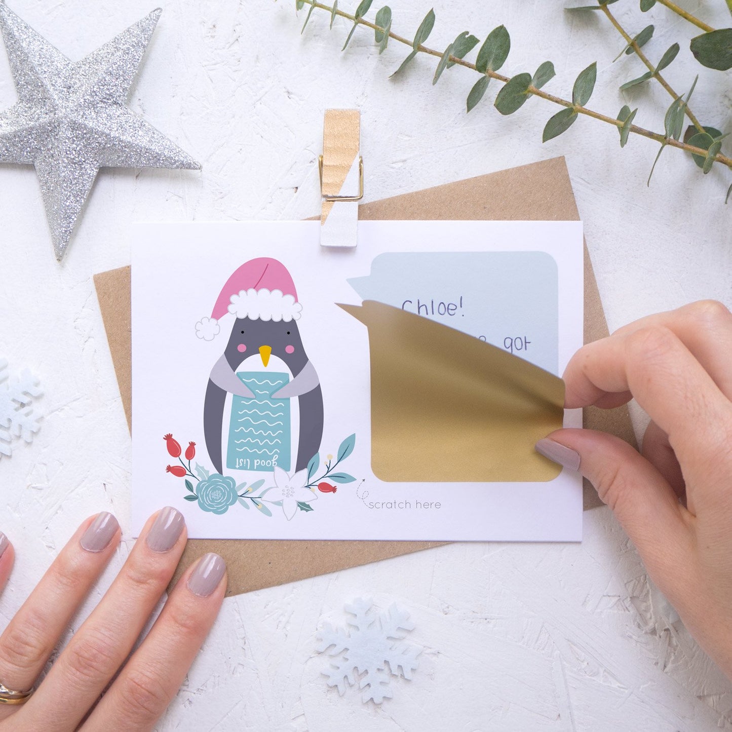 Personalised Penguin secret message Christmas scratch card with the scratch and reveal panel being applied.