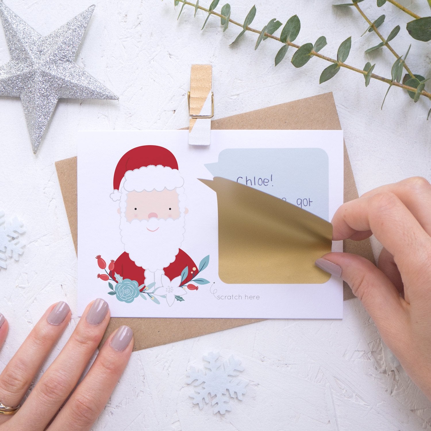 Personalised Santa secret message Christmas scratch card with the gold scratch and reveal panel being applied.