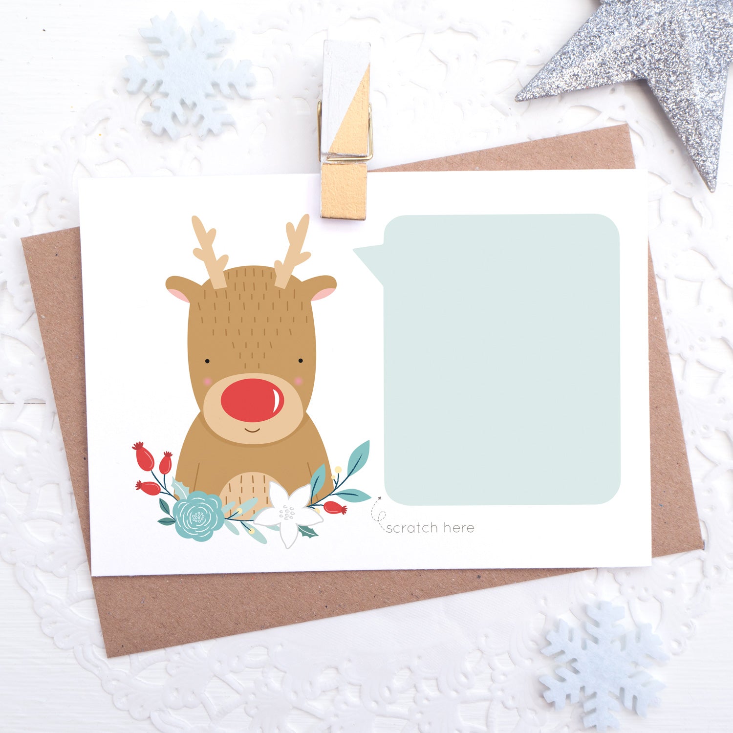 A christmas themed, write your own message scratch and reveal card featuring a red nosed reindeer, some winter florals a big blue blank area for you to hand write your message.