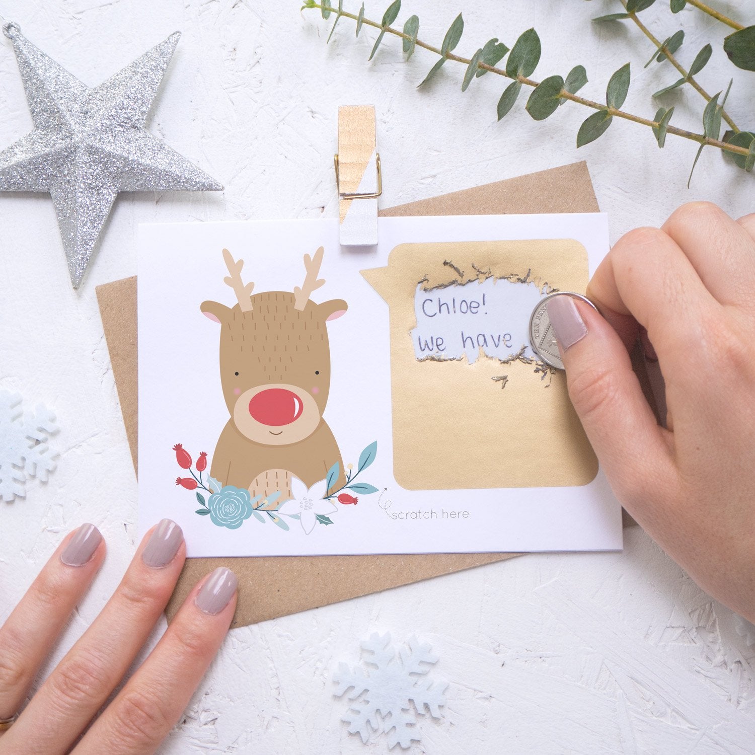Personalised reindeer secret message Christmas scratch card being scratched off with a coin.