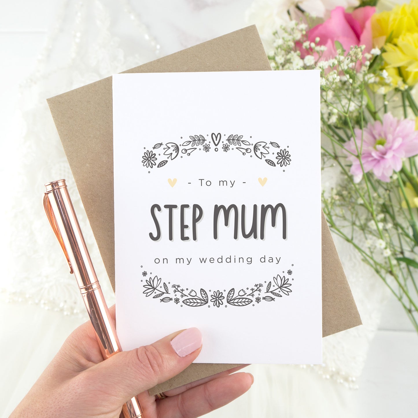To my step mum on my wedding day. A white card with grey hand drawn lettering, and a grey floral border. The image features a wedding dress and bouquet of flowers.