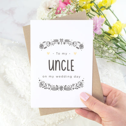 To my uncle on my wedding day. A white card with grey hand drawn lettering, and a grey floral border. The image features a wedding dress and bouquet of flowers.